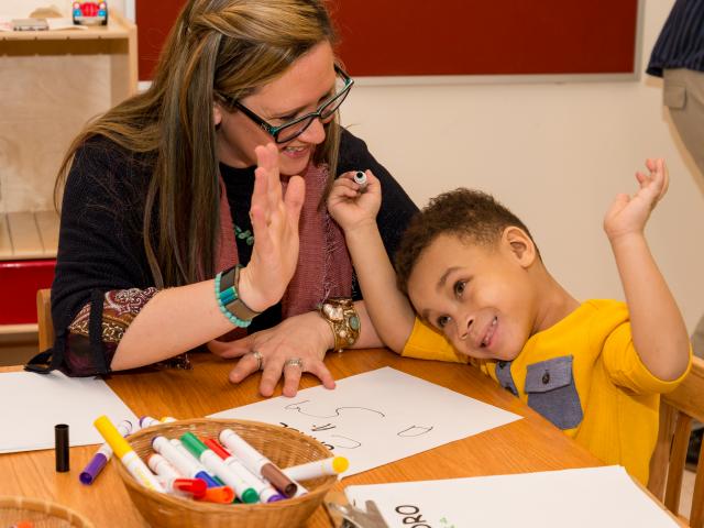 Kean early childhood education student works with a young boy in the Kean Child Care Center