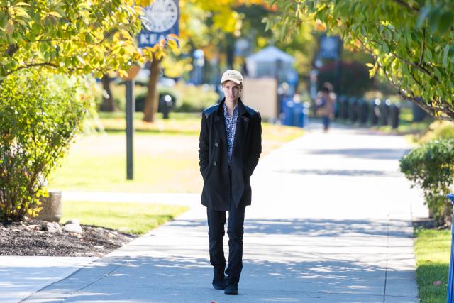 A young man walks along Cougar Walk in the Fall