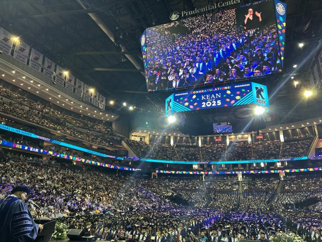 Crowd of graduates, families and guests fill the stadium.