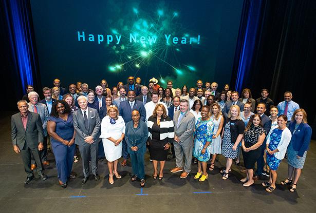 President Repollet onstage with Kean senior leadership. Behind them is a sign, Happy New Year.