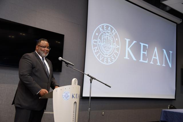 Kean President Lamont Repollet speaks at a podium.