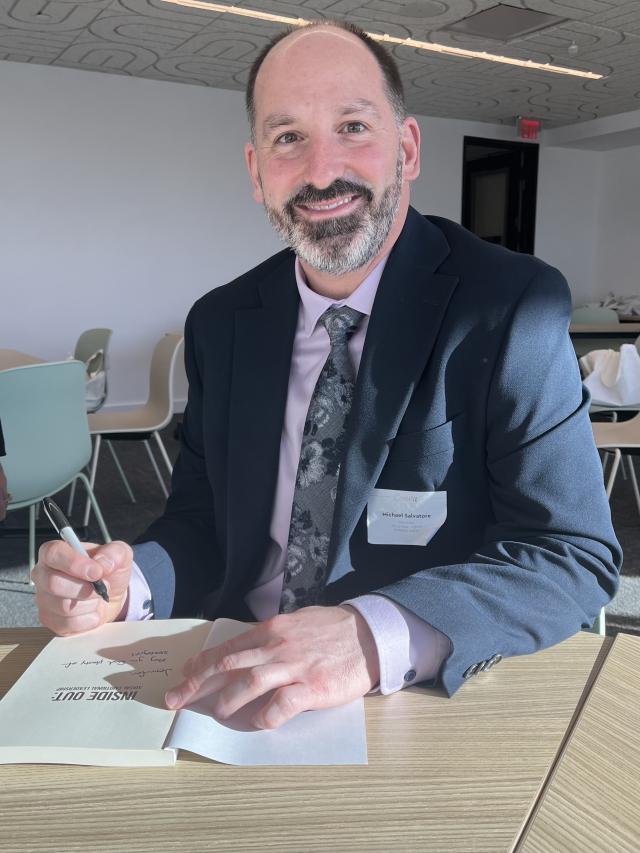 Mike Salvatore signs a copy of his book