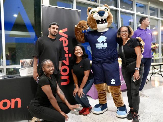 Smiling students gather around Keanu the Cougar mascot at the step show.