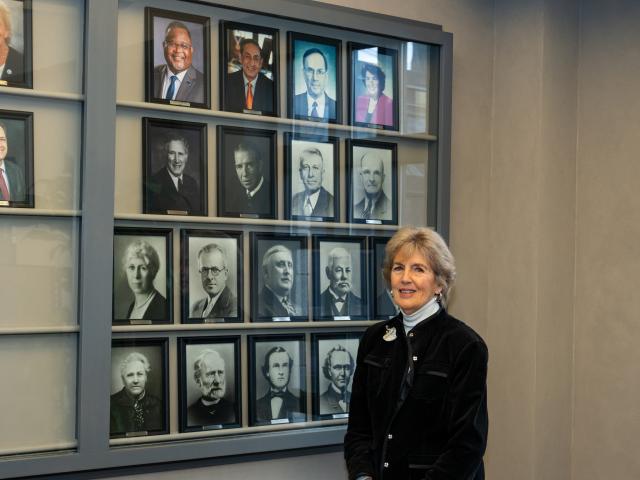 Dr. Bernice “Bernie” VanSteyn-Weiss stands in front of a display of Kean presidents' photos