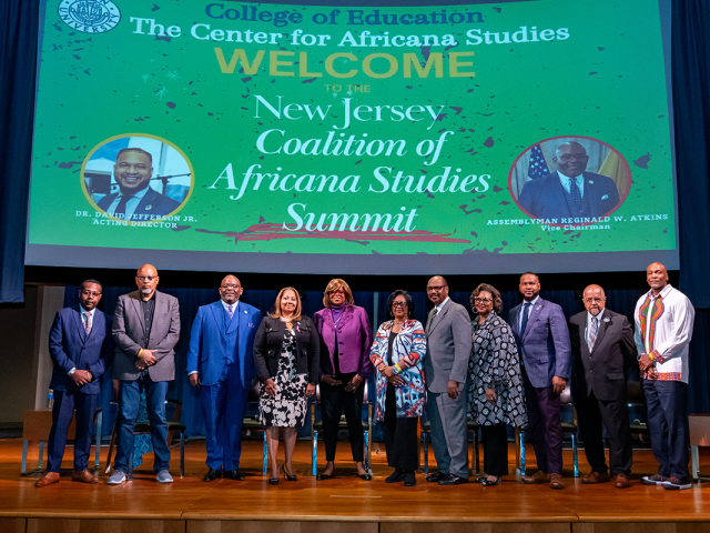 The speakers and panelists at the NJ Coalition of Africana Studies Summit pose on stage.