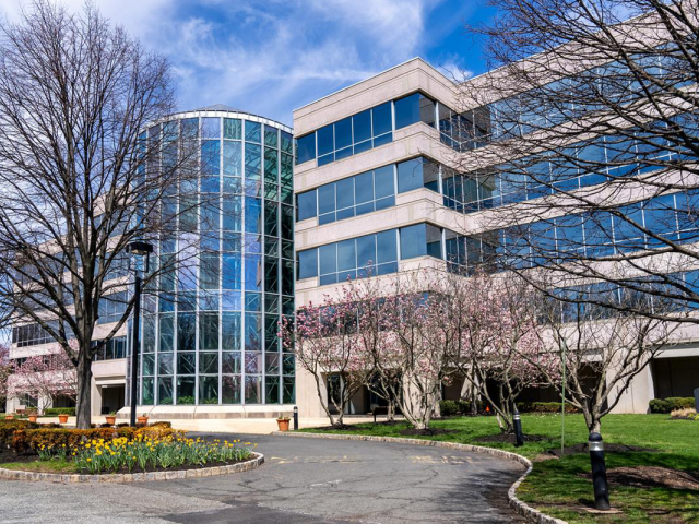 The 1085 Morris Avenue Building, with many glass windows and a path leading to the front entrance.