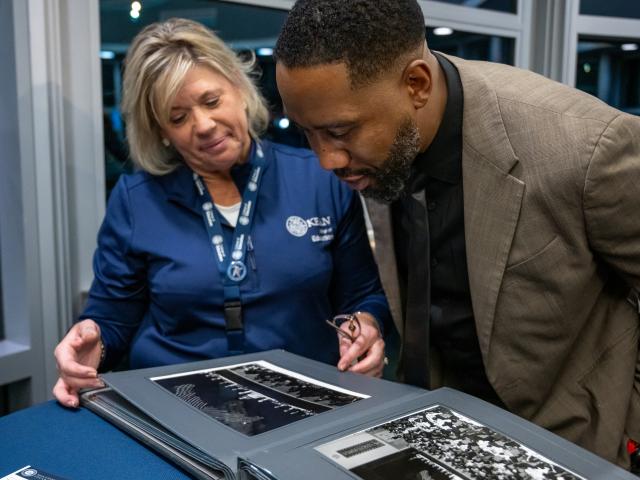 Daun Ward and Ndaba Mandela look at photos of the late Nelson Mandela in an album