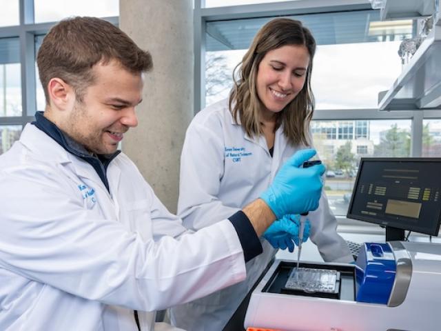 A Kean student and a faculty member conduct research in a laboratory