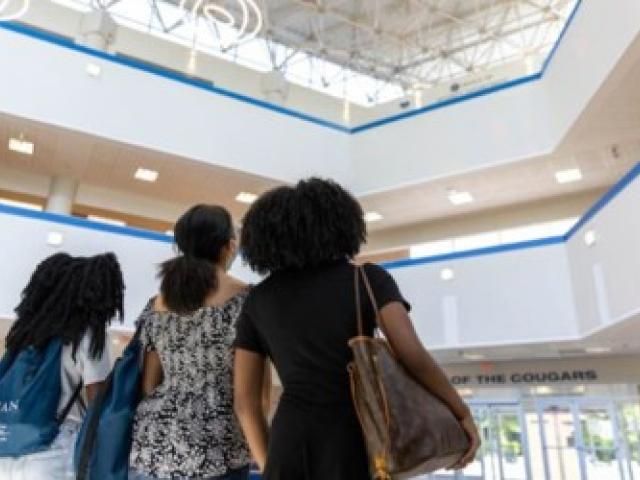 Three young women look forward and upward at Kean University. 