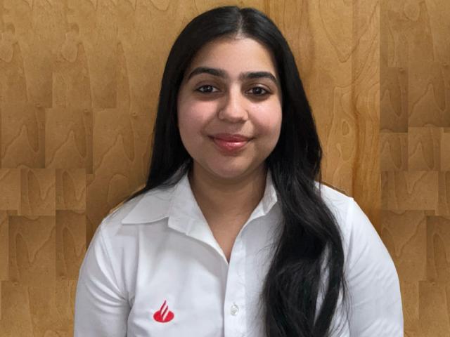 girl with long straight black hair wearing a white shirt with a red Santander Bank logo on the right
