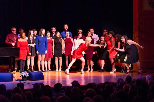 Kelli O'Hara leans over to share microphone with students to showcase their talents.