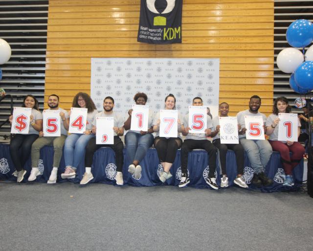 Kean University students proudly display the fundraising tally for the Kean Dance Marathon.