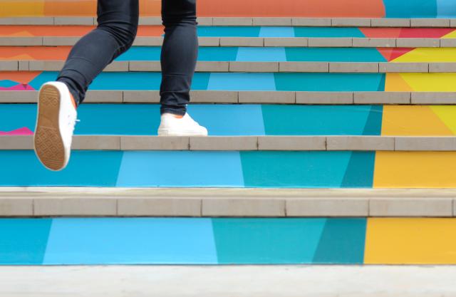 Student climbs brightly colored staircase