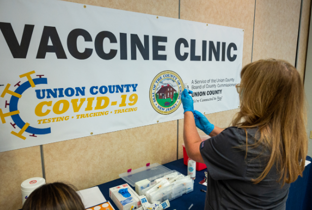 A nurse prepares a COVID-19 vaccine at the vaccination site on Kean University's campus.