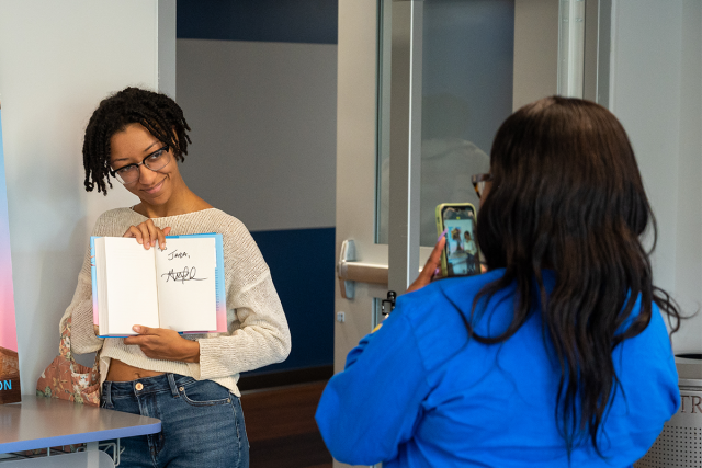 A student shows off a book, autographed by author George M. Johnson, at the 2022 Common Read.