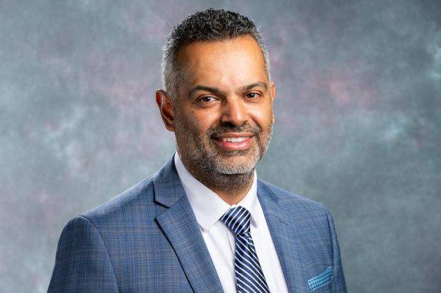 Marvin Adames, in a blue suit, white shirt and striped blue tie