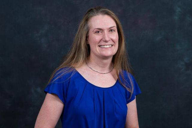 Laura Lorentzen, with long light-brown hair in a blue blouse, smiles.