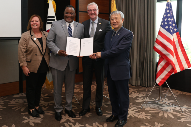 Kean President Repollet and Chief of Staff Audrey Kelly, with Governor Murphy hold signed agreement.