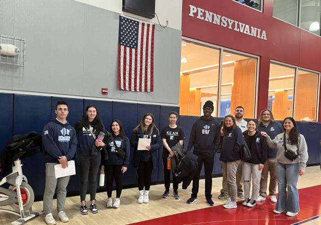 Students from Kean's KUBS program stand on the basketball court at U Penn