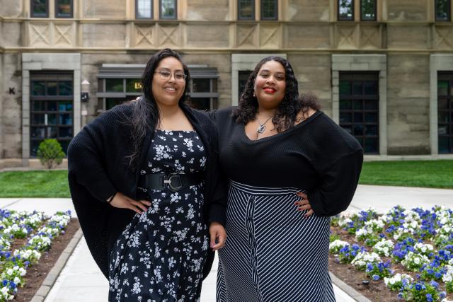 The smiling mother and daughter pose in front of Kean Hall.