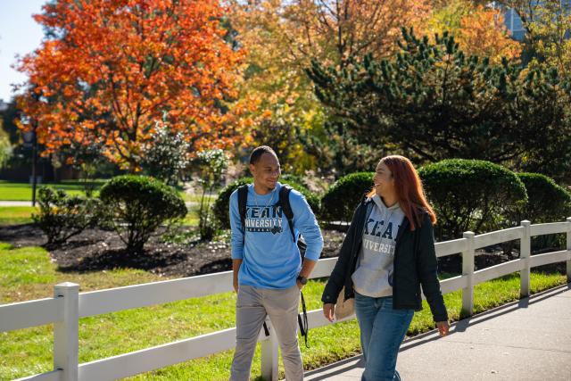 Two Kean students walk along Cougar Walk on a beautiful Fall day 