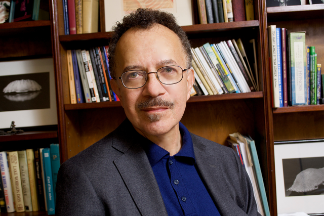 Playwright Benjamin V. Marshall poses in front of a bookshelf.