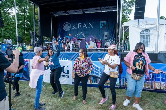 A group of women festival-goers dance at the Jazz & Roots Music Festival.