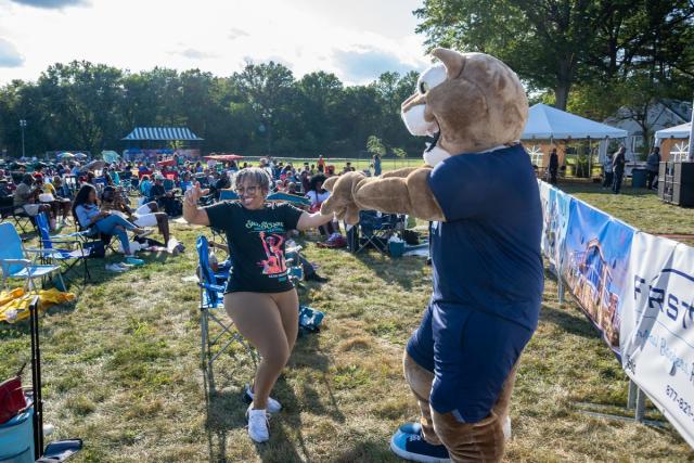 Keanu the cougar, the Kean mascot, dances with a woman attending the festival.