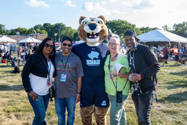 The Kean mascot, Keanu the Cougar, poses with a group of festival-goers.