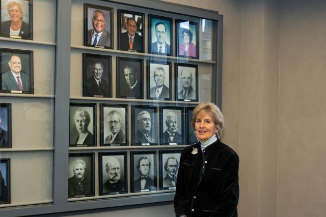 Dr. Bernice “Bernie” VanSteyn-Weiss stands in front of a display of Kean presidents' photos