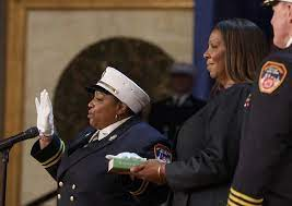 Rev. Pamela Holmes being appointed, wearing white hat, white glove and navy blue chief uniform with a female presenting figure and male presenting figure standing next to her.