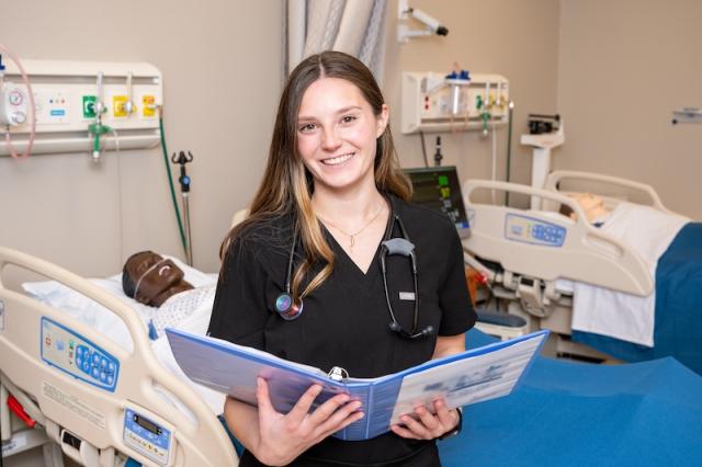 A nursing student takes a class in a clinical environment