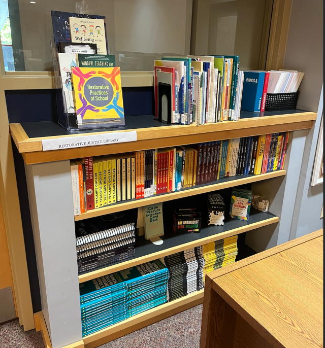 Four bookshelves in the Holocaust Resource Center full of restorative justice books and other materials