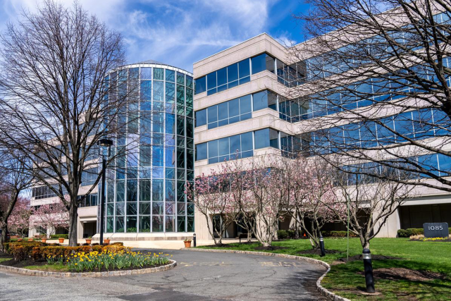 The 1085 Morris Avenue Building, with many glass windows and a path leading to the front entrance.