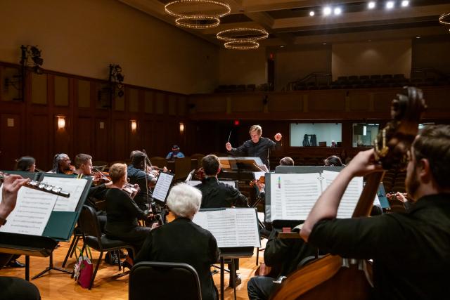 Kean University Orchestra musicians on stage at Enlow Hall, view of conductor Warren Cohen leading the group.