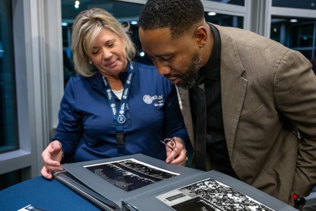 Daun Ward and Ndaba Mandela look at photos of the late Nelson Mandela in an album