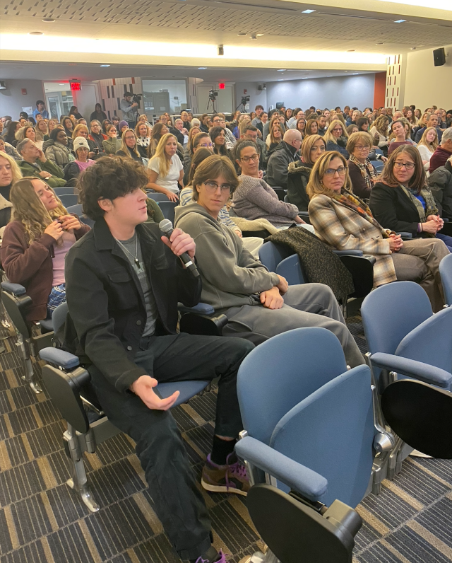 High schoolers ask Dr. Sliwa and Dr. White questions during Q&A while audience members look on.