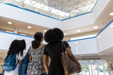 Three young women look forward and upward at Kean University. 